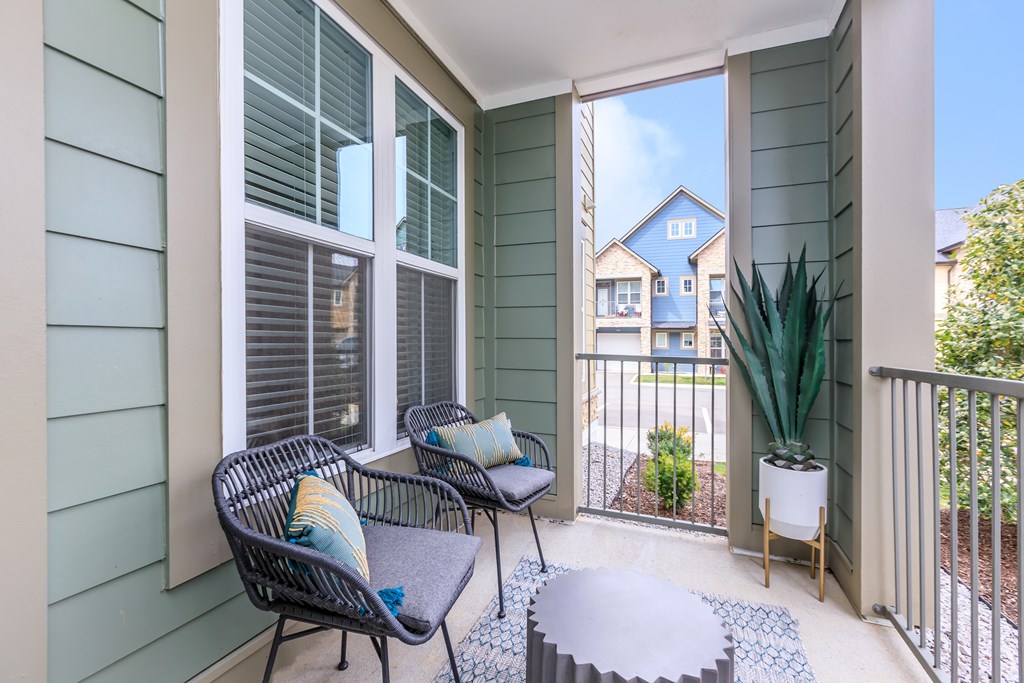 A balcony with a chair and a table.