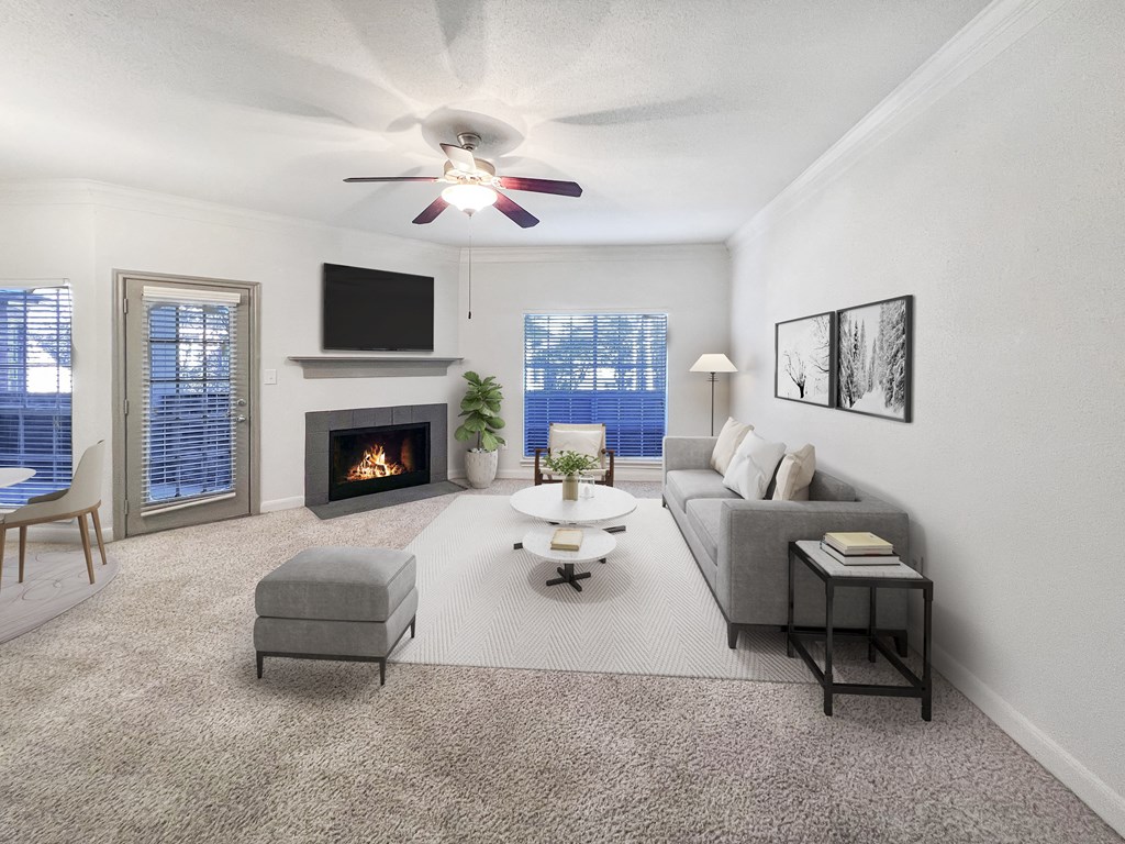 an open living room with a ceiling fan and a fireplace