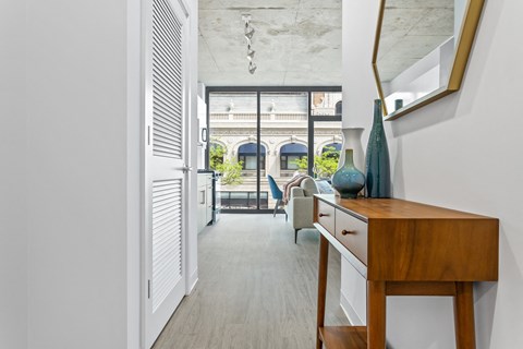 a hallway with a desk and a door to a living room