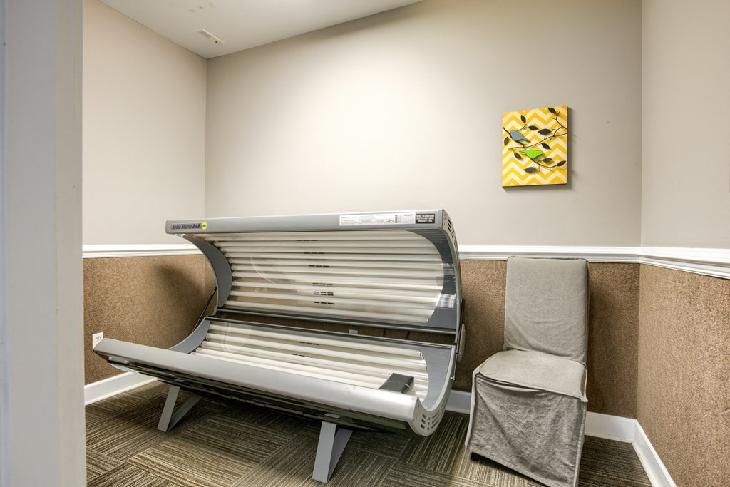 a waiting room with two chairs and a bench and a painting on the wall