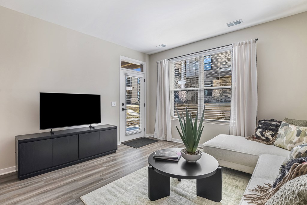 A living room with a flat screen TV and a white couch.