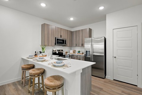 A kitchen with a white countertop and stainless steel appliances.