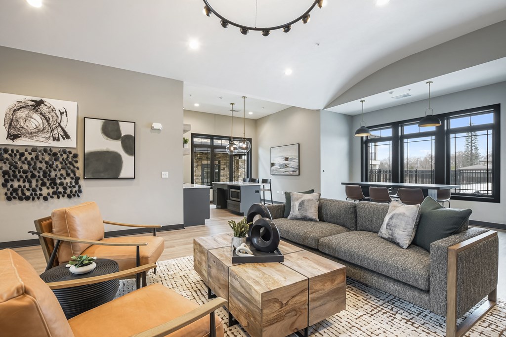 A modern living room with a grey sofa, wooden coffee table, and a large window.