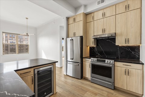 A kitchen with wooden cabinets and a marble countertop.