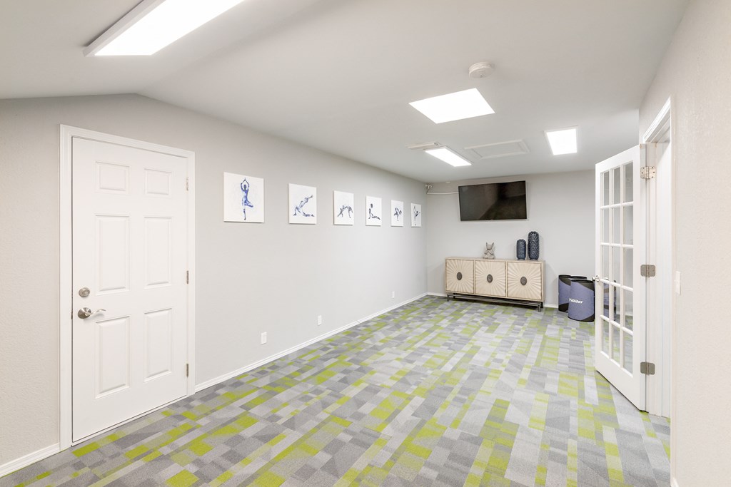 an empty room with a door and a tv on the wall