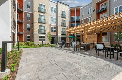A patio area with a table and chairs is surrounded by apartment buildings.