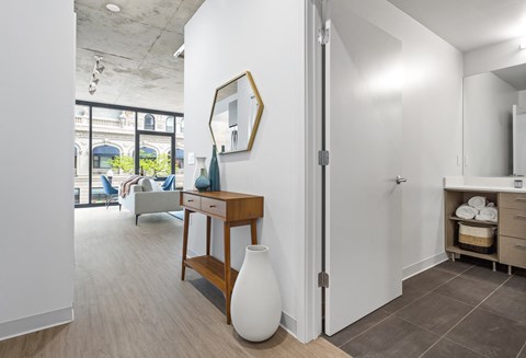 a hallway with a desk and a mirror in a house