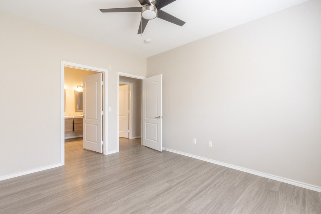 a bedroom with a ceiling fan and hardwood floors
