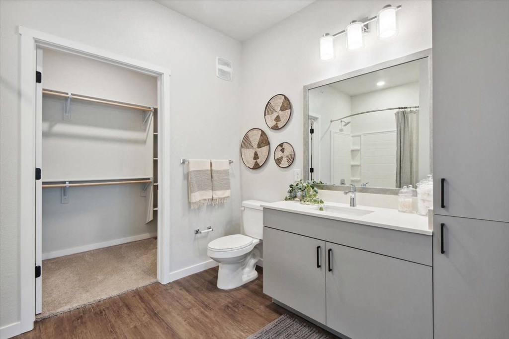 a white bathroom with a large mirror and a toilet