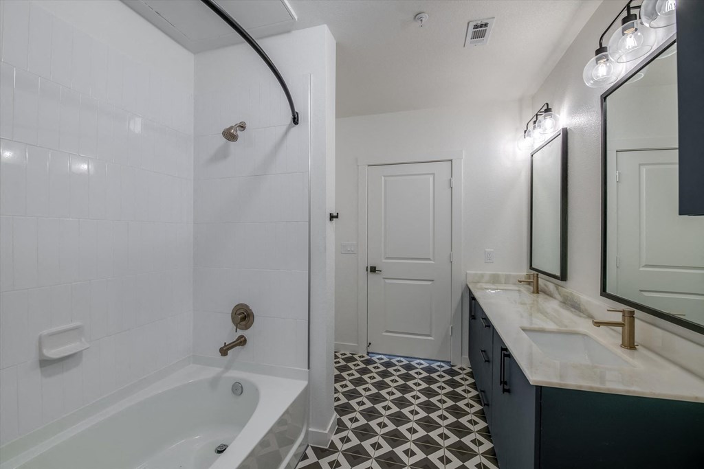 a bathroom with a tub and a sink and a mirror