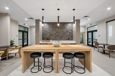 A modern dining room with a wooden table and black stools.