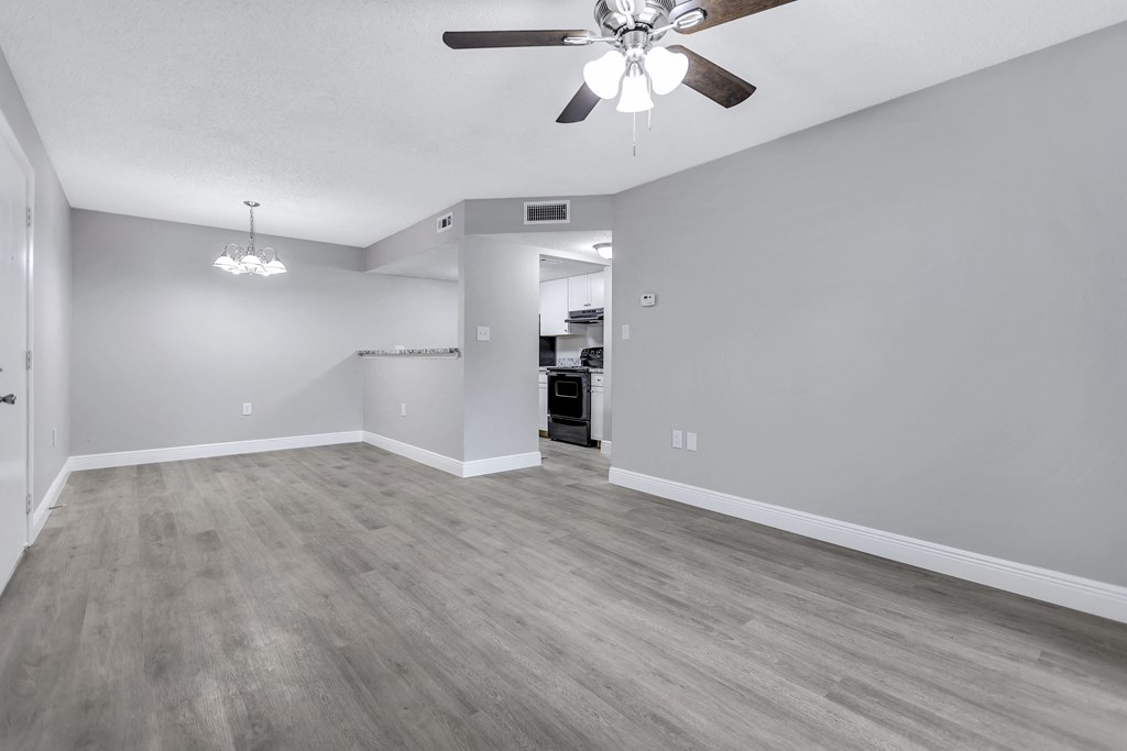 the living room of an empty house with a ceiling fan