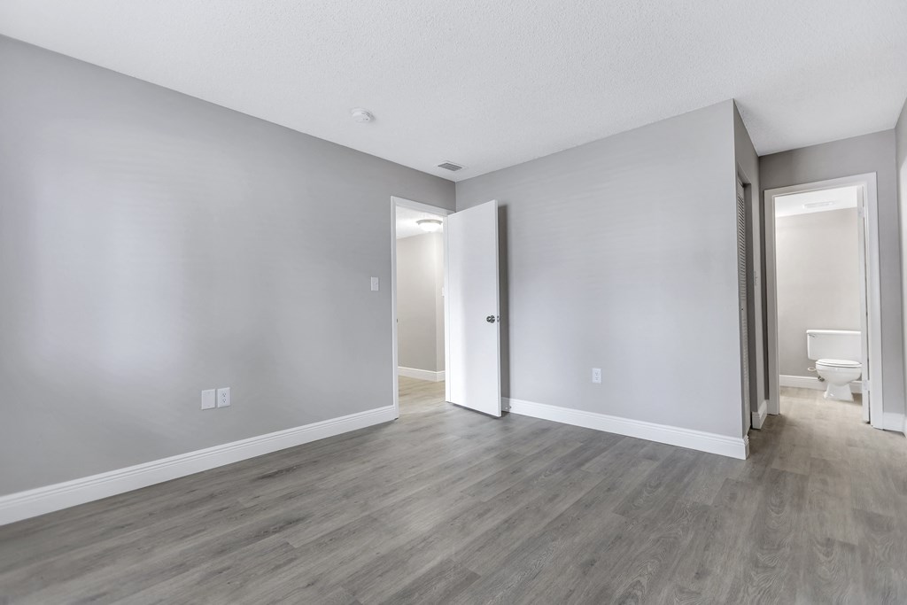 an empty living room with white walls and wood flooring