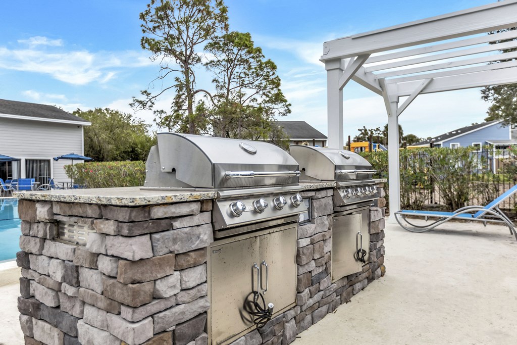 an outdoor kitchen with two stainless steel appliances and a grill