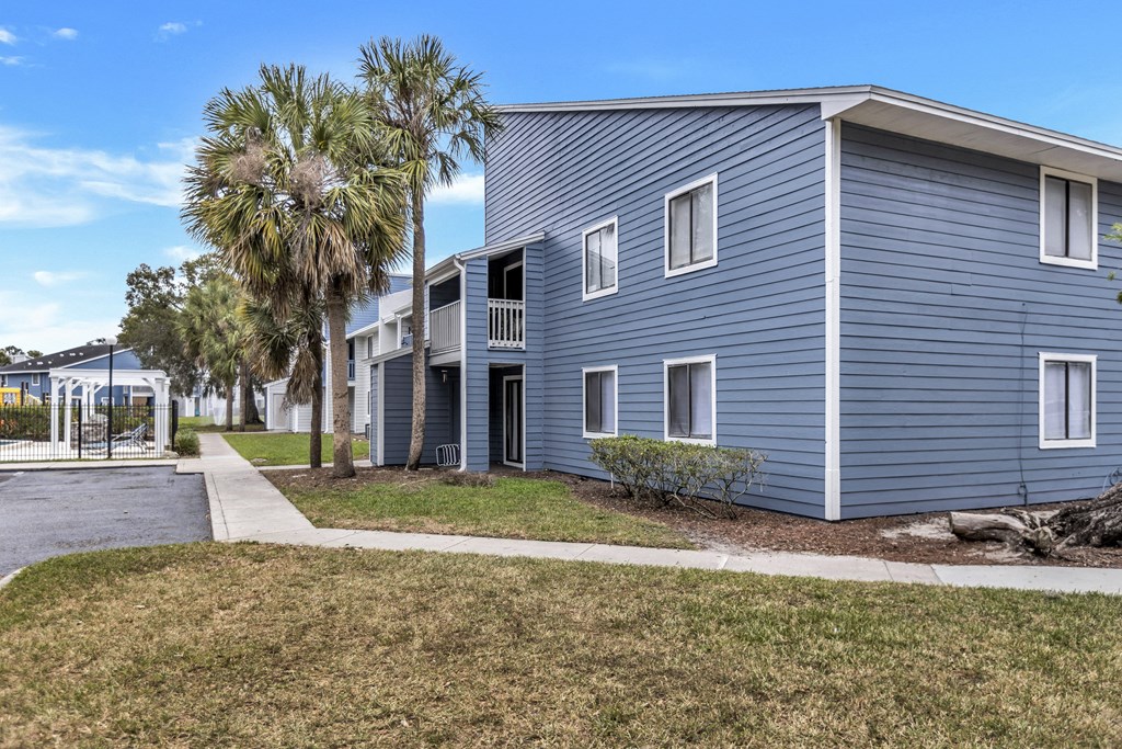 a blue building with palm trees in front of it