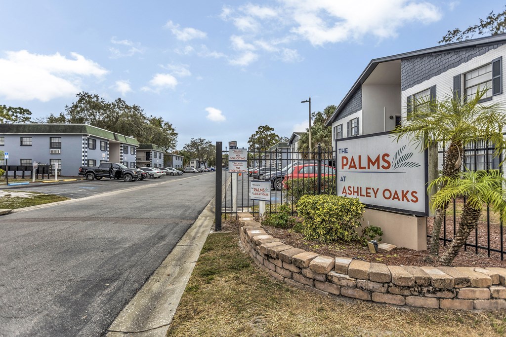 the sign for palms oaks at the entrance to a street with houses