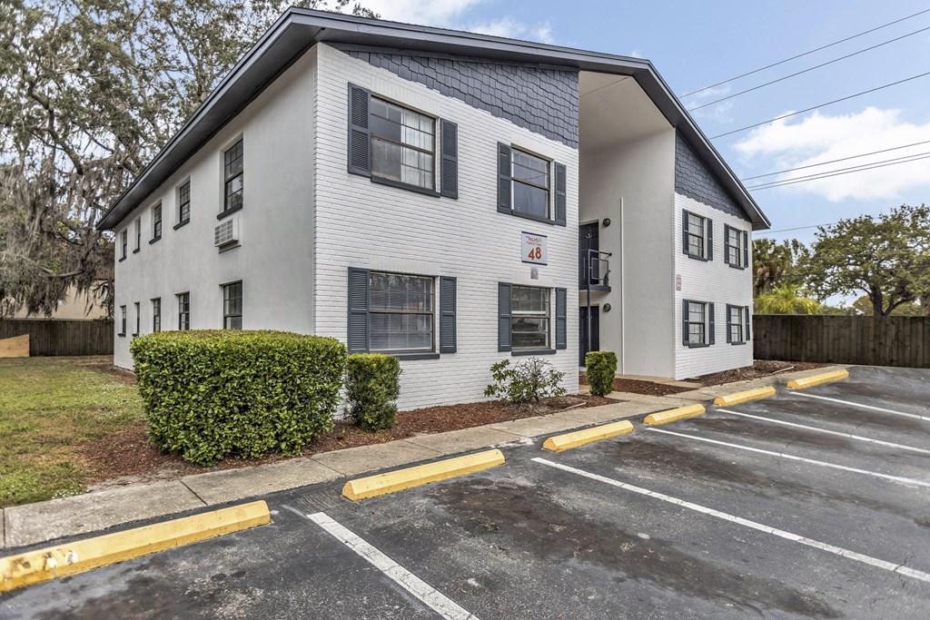 a white apartment building with a parking lot