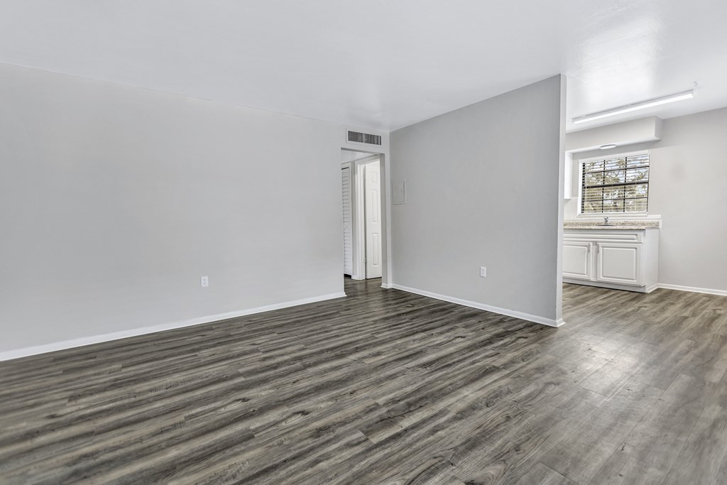 an empty living room with white walls and wood flooring