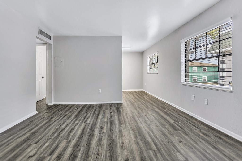the living room of a new home with a large window and wood flooring