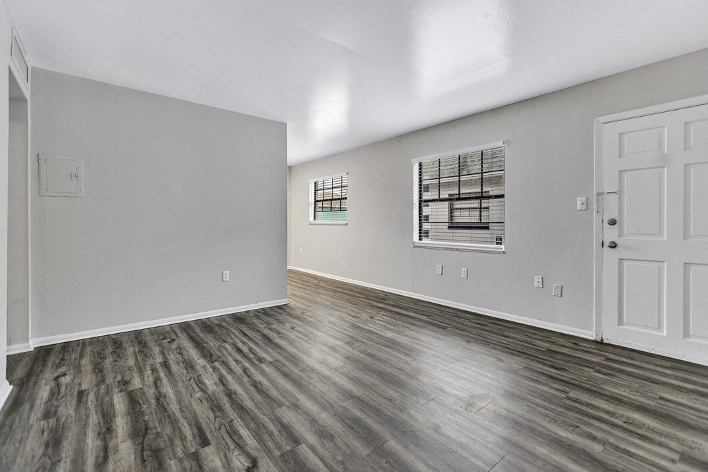 the living room of a new home with white walls and wood flooring