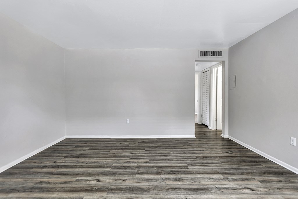 an empty room with white walls and a wood floor
