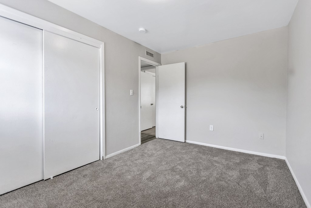 an empty bedroom with white walls and white doors