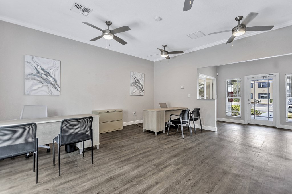 a living room with a table and chairs and ceiling fans