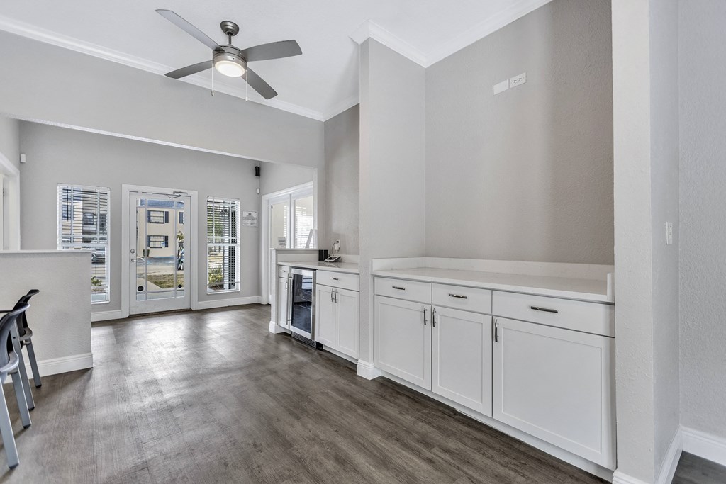 a kitchen with white cabinets and a ceiling fan
