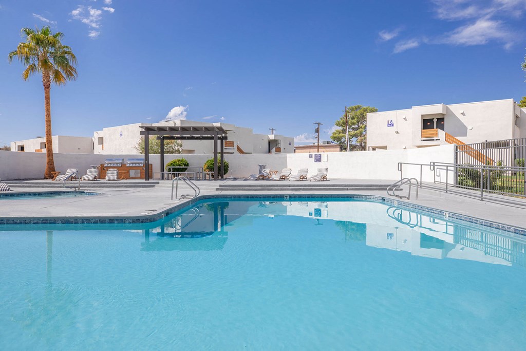 a large swimming pool at a resort style building with a palm tree