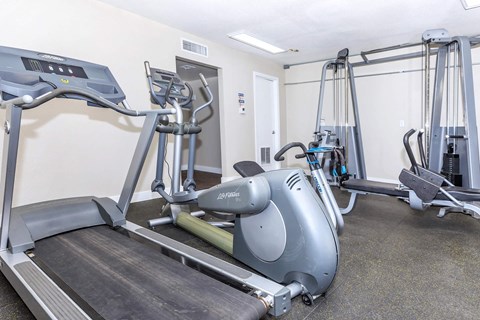 a gym with two treadmills and other exercise equipment