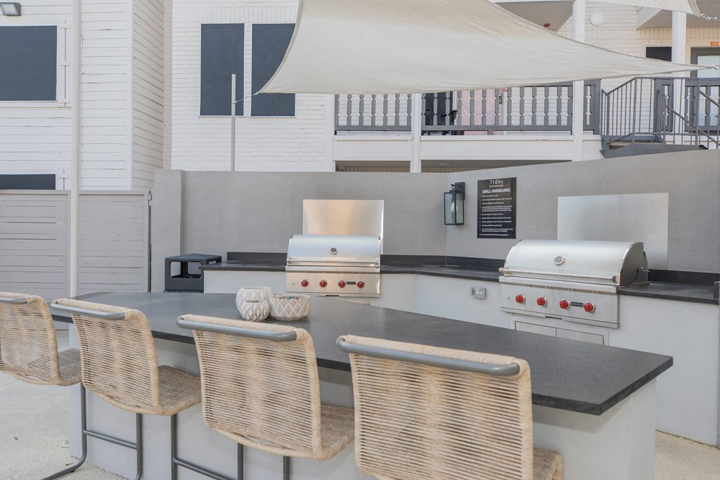 a kitchen with a bar with chairs and a grill
