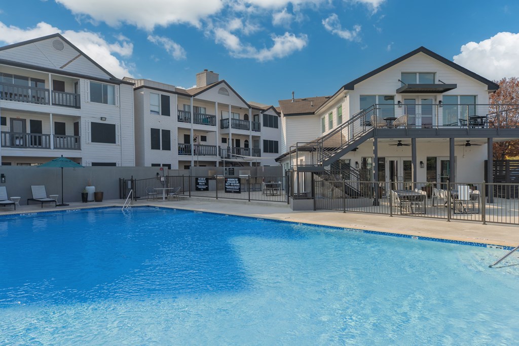 a large swimming pool in front of an apartment building