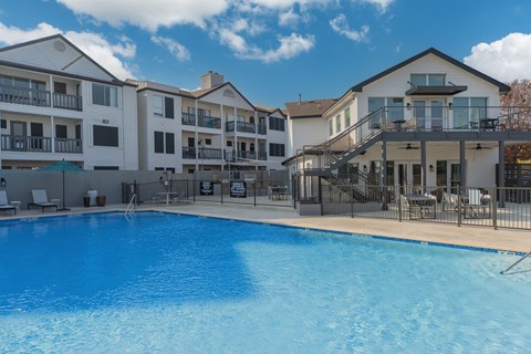 a large swimming pool in front of an apartment building