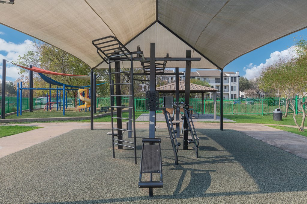 a playground with a swing set and climbing equipment in a park
