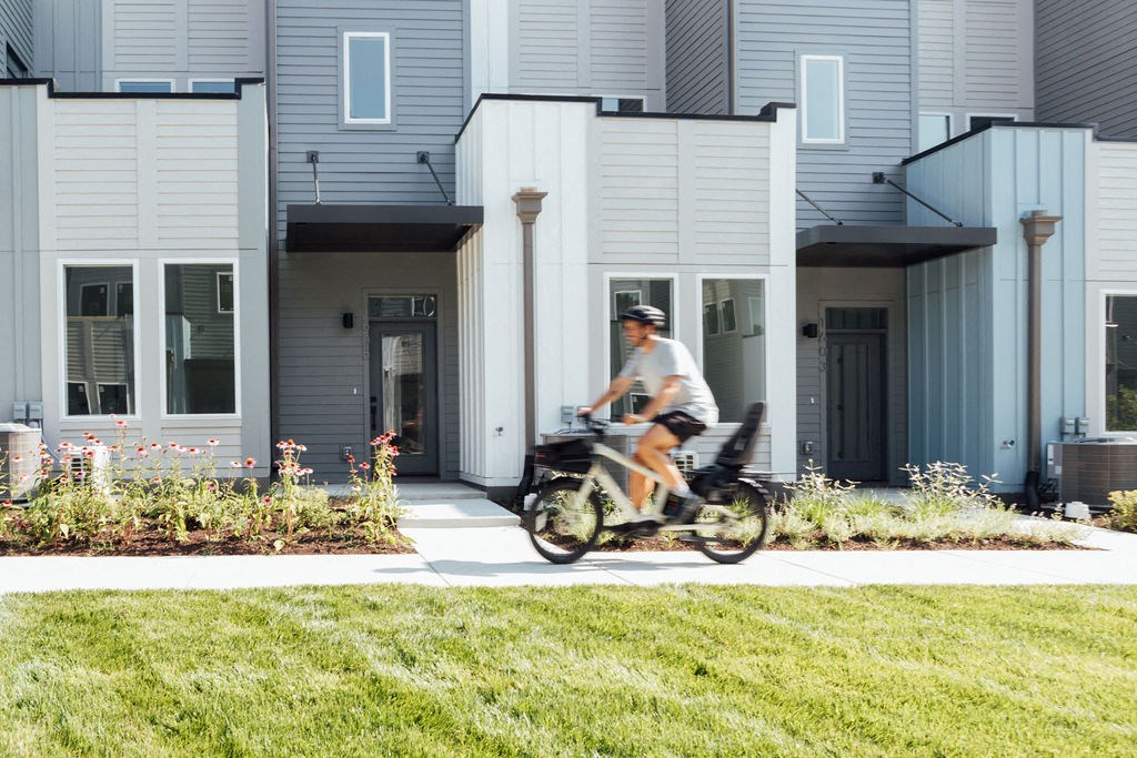 a man riding a scooter in front of an apartment building