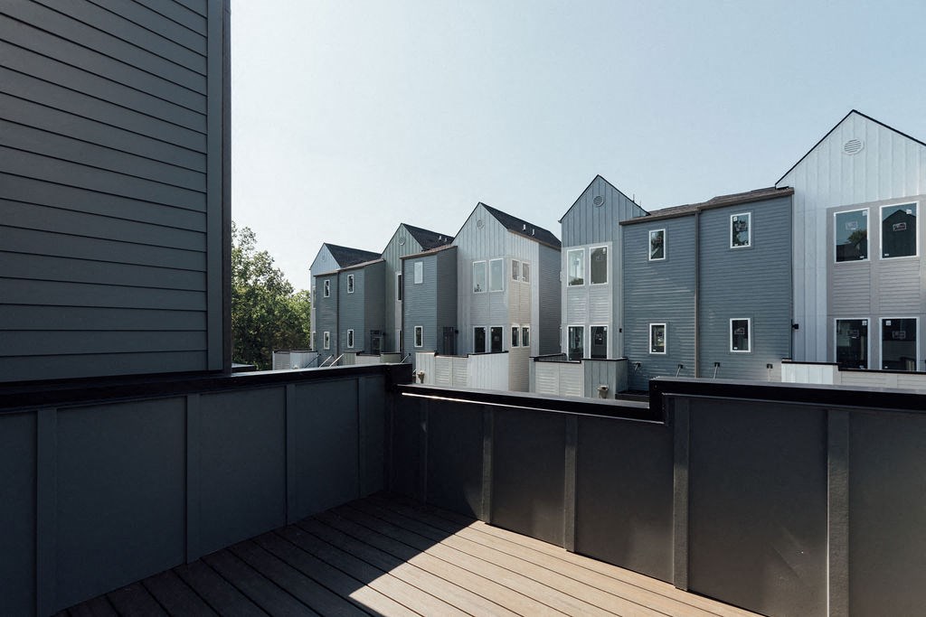 a view from a balcony of a row of houses in the distance