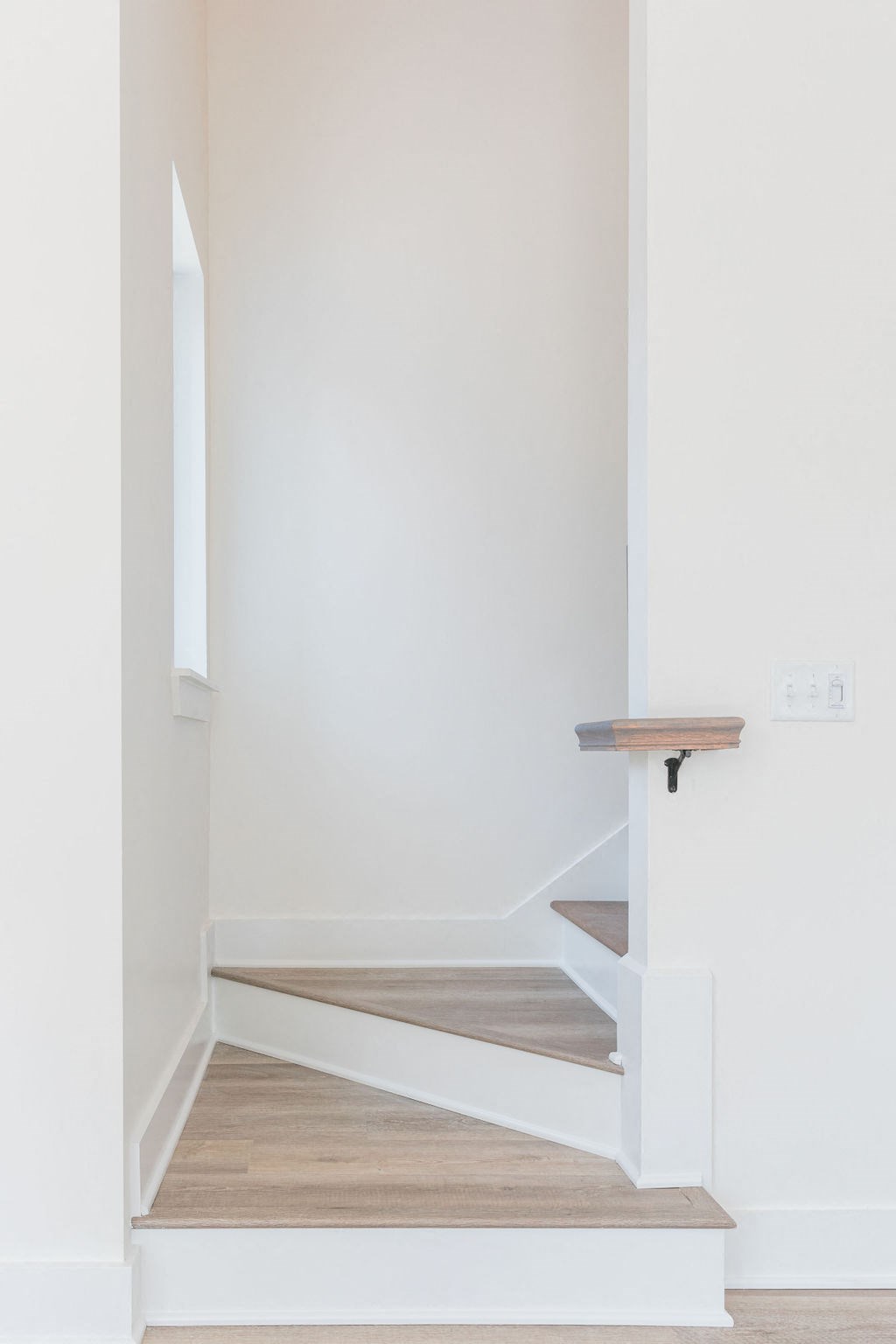 a small staircase in a home with white walls and wood floors