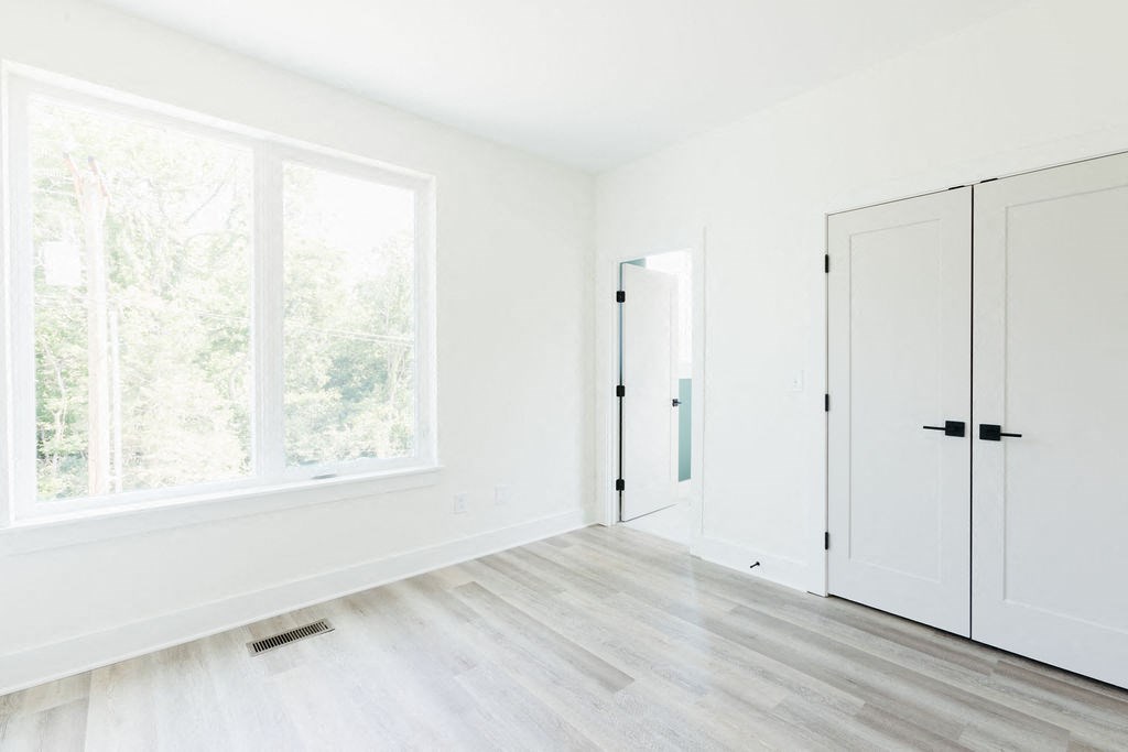 an empty room with white walls and a large window