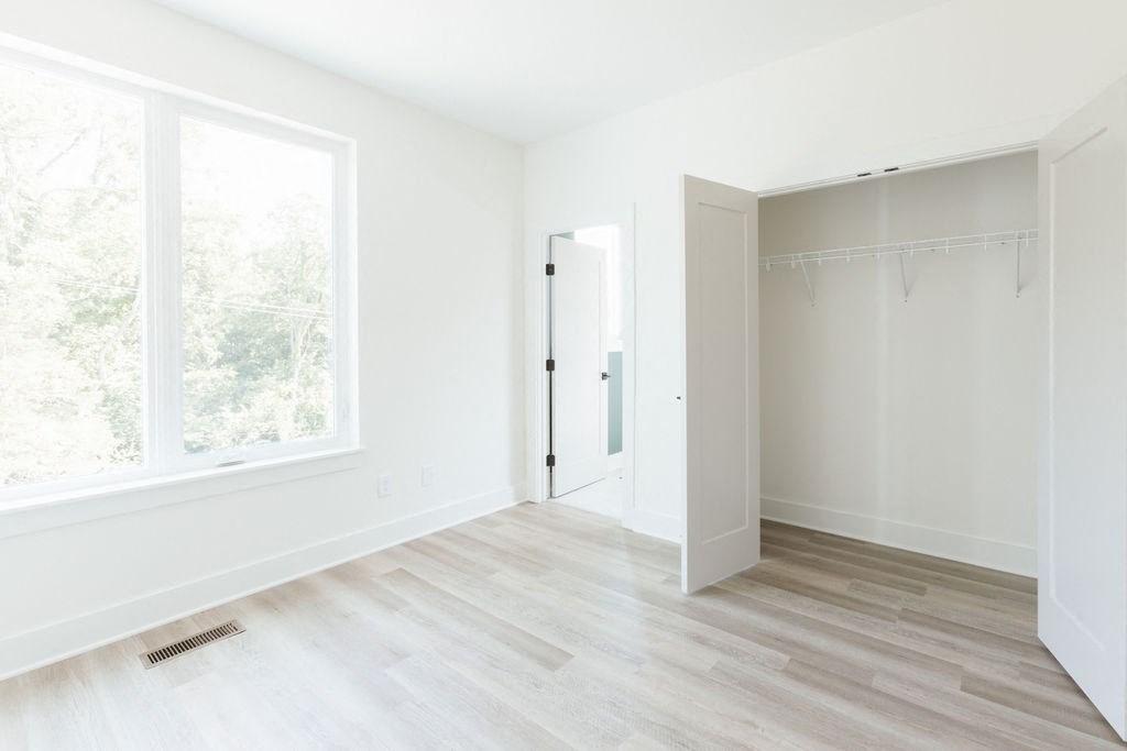 an empty room with a large window and white walls