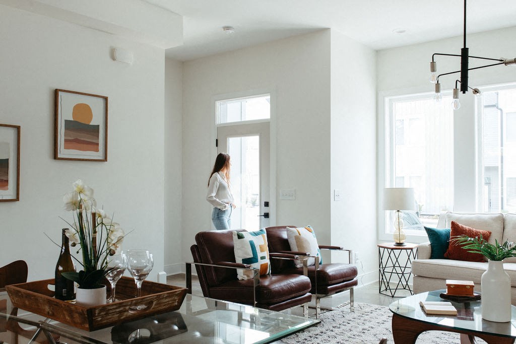 a living room with a woman standing at the door