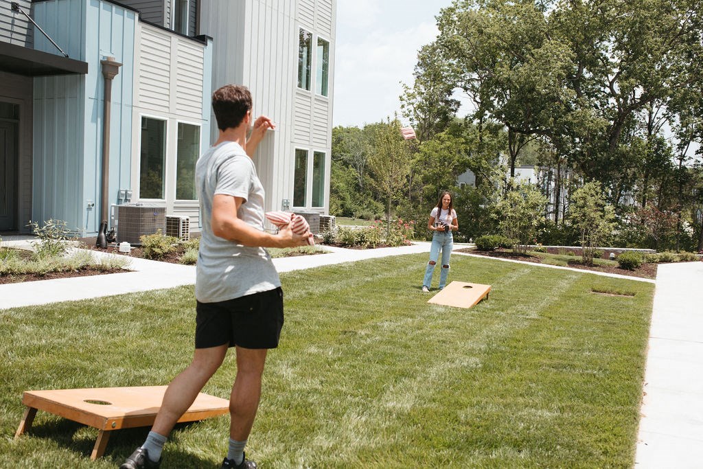 a man and a woman playing frisbee on a lawn