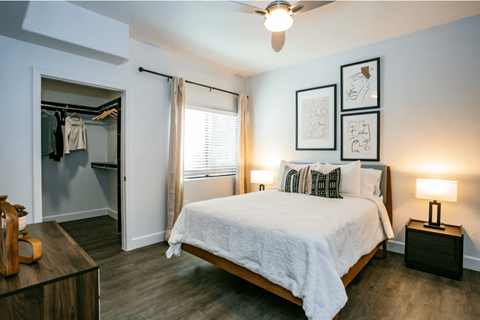 A bedroom with a bed, nightstand, and a ceiling fan.