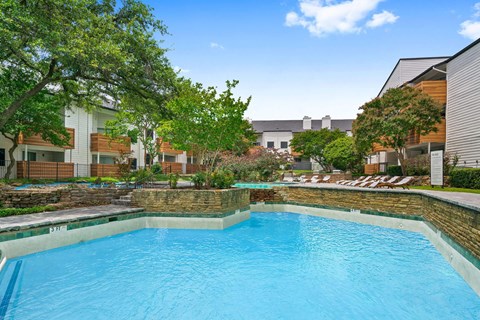 a swimming pool at an apartment building with a blue pool