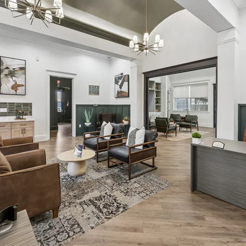 A modern living room with a dark wood coffee table and brown leather couches.
