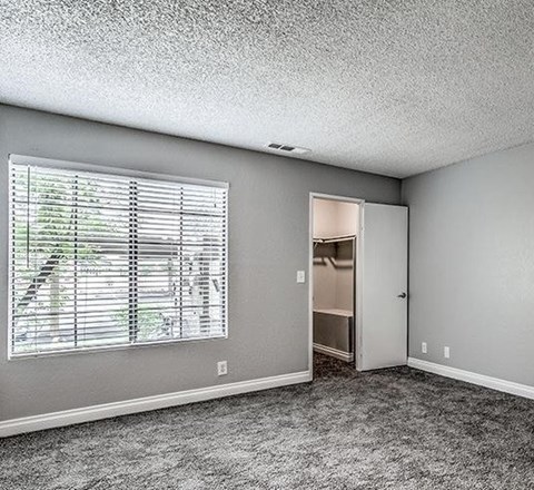 A room with a window and a door leading to another room.