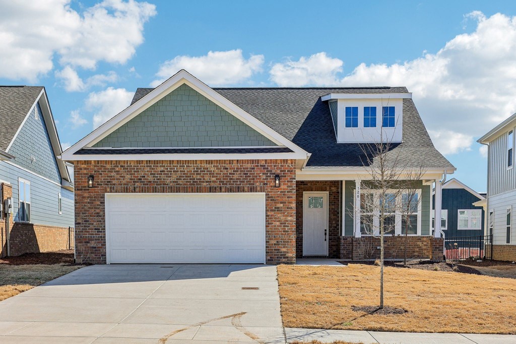 A house with a white garage door and a brick wall.