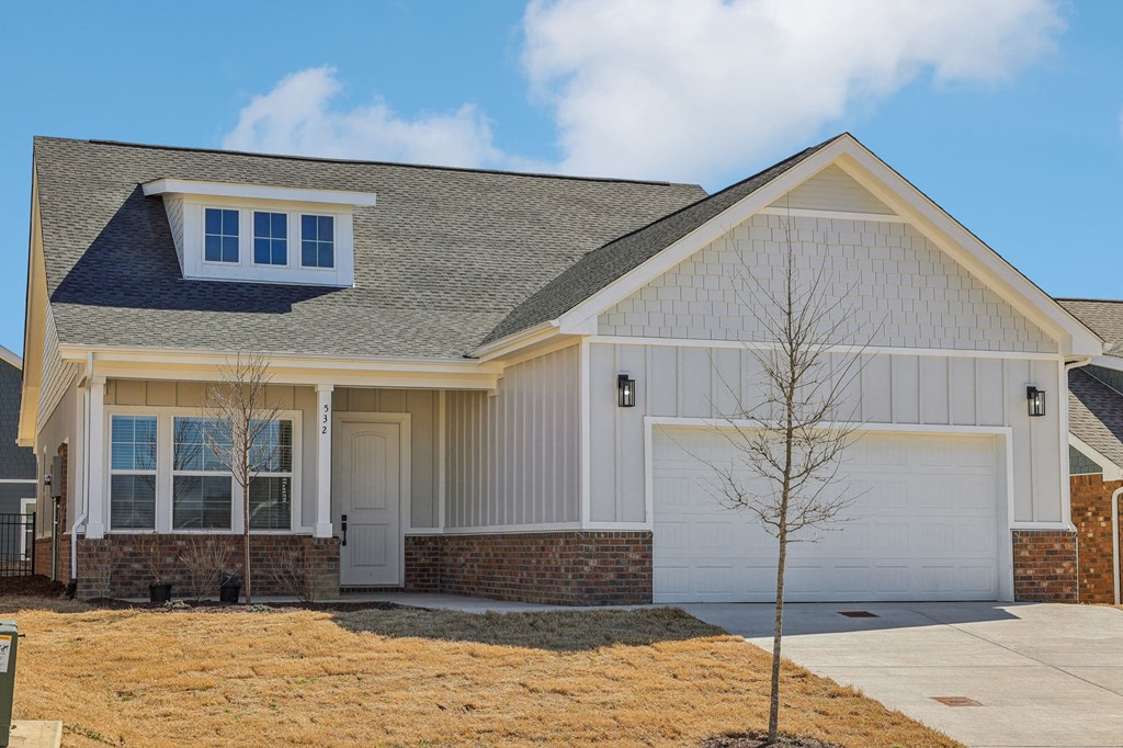 A house with a white garage door and a grey roof.