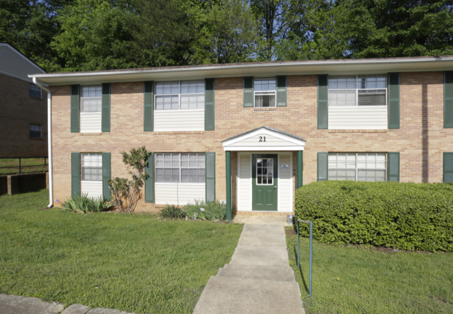a house with green shutters and a green door