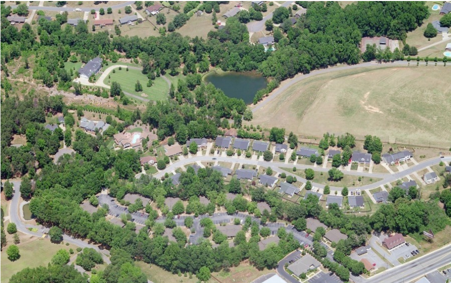 arial view of a neighborhood with a lake in the middle