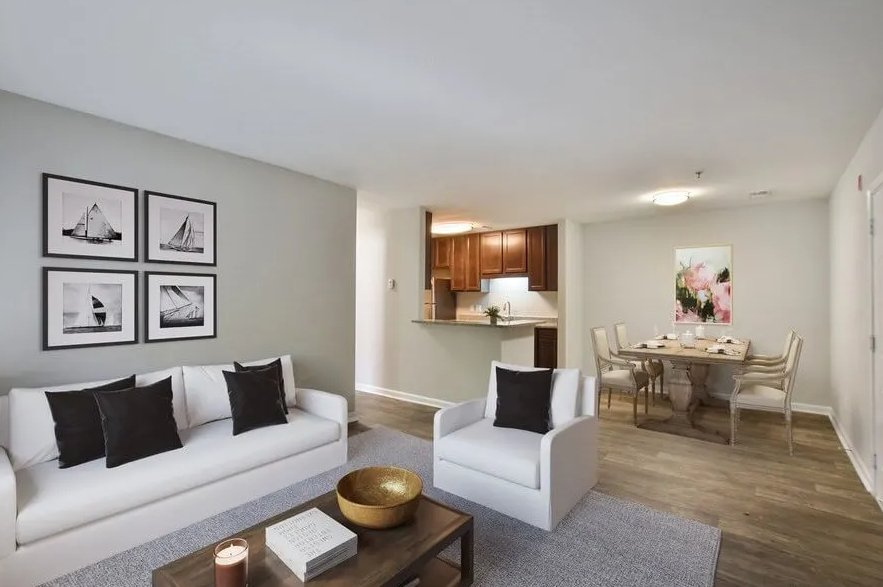 a living room with two white couches and a table with chairs